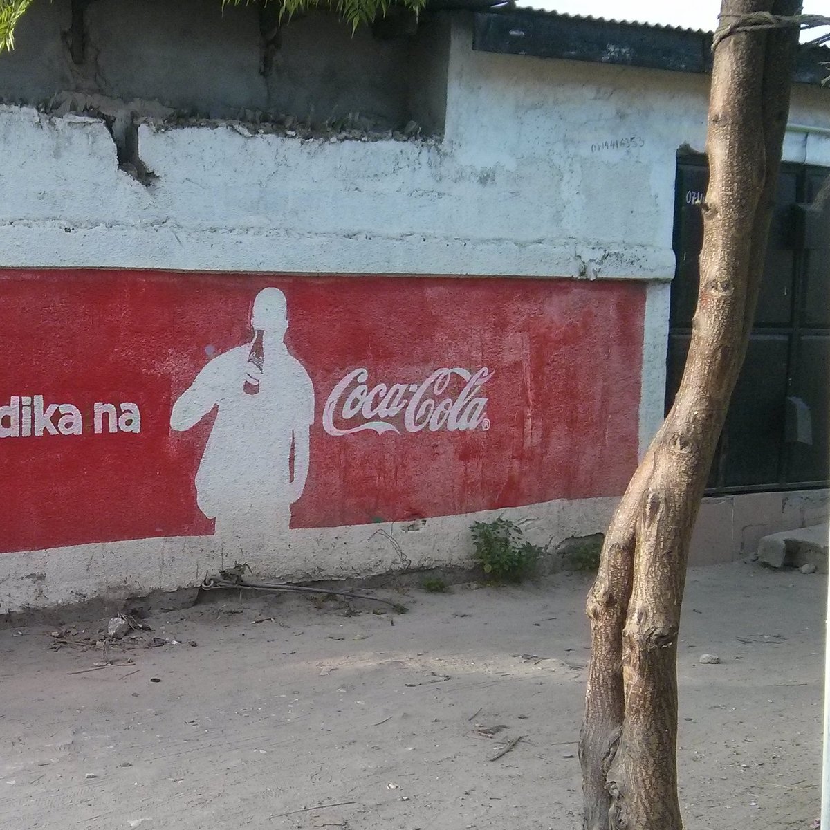 das Foto zeigt eine Wand, die mit Werbung von Coca-Cola bemalt ist